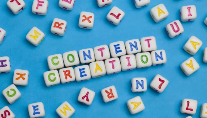 imagem de quadradinhos de letras, em um fundo azul claro, escrito content creation (criação de conteúdo) e letras espalhadas.