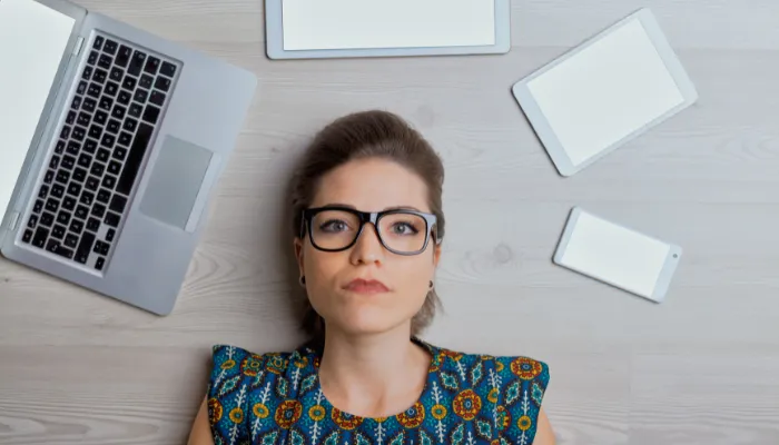 mulher deitada, entre computador e outros produtos da Apple, representando transformando necessidades em vendas de seguro de vida por telefone.
