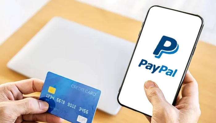 Método de pagamento Paypal representado por um celular aberto no paypal e um cartão de crédito.