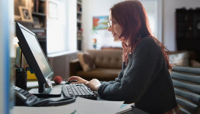 Exportação Manual de Pedidos no WooCommerce representado por uma mulher mexendo no computador.