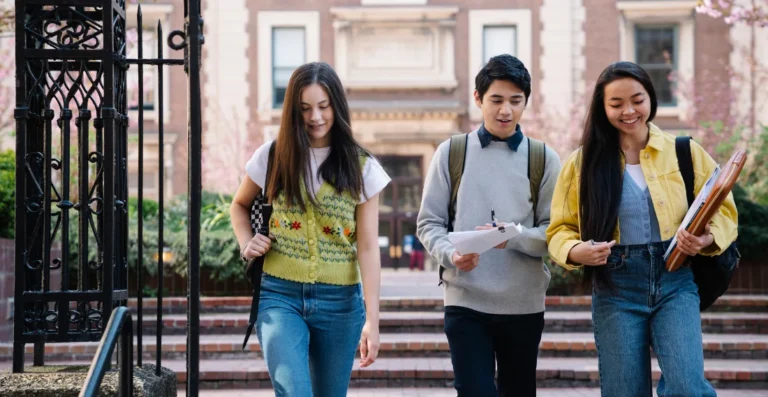 Alunos de faculdade, caminhando, representando campanha de captação de alunos.